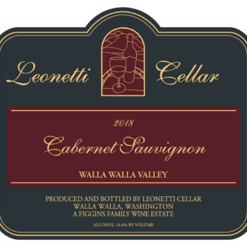 Leonetti Cabernet Sauvignon 2018; A black rectangular label with a gold border. A central maroon stripe with gold text. A small gold bordered maroon 'stained window' above with a gold line drawing od bottle and glass with gold text to each side and below the central bar.