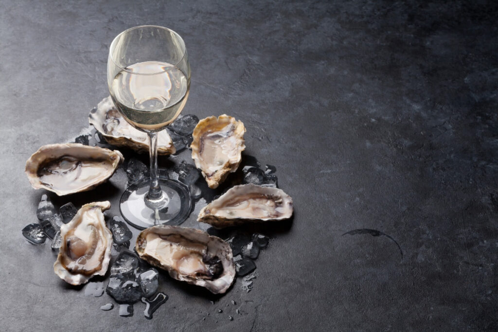 best wine for fish - shellfish. fresh oysters surrounding a glass of wine